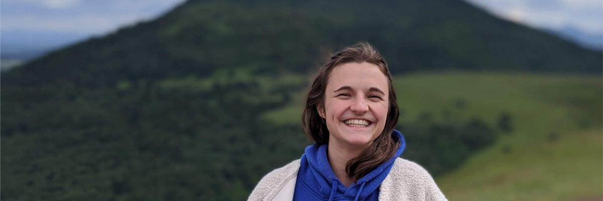 Image of a woman smiling at camera with a mountain in the background