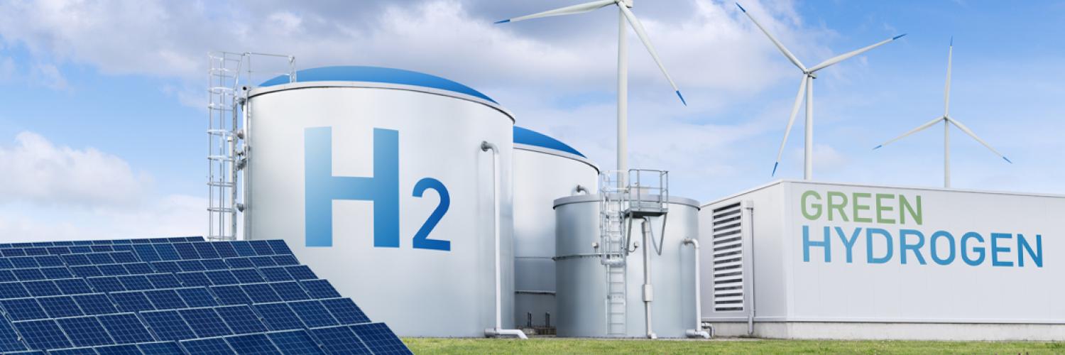 Large white silos with blue letters and a windmill in the background