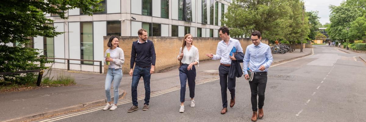 Five people walking together in a row, talking