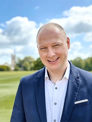 image of a person wearing a suit smiling at the camera