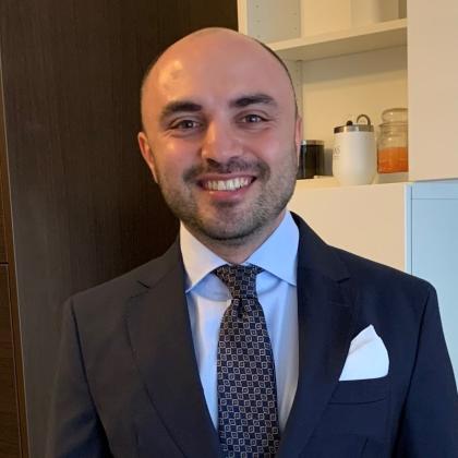 Image of man wearing a suit and tie smiling at the camera