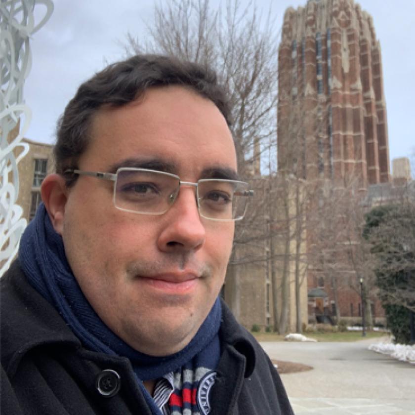 Image of a man with glasses smiling at camera